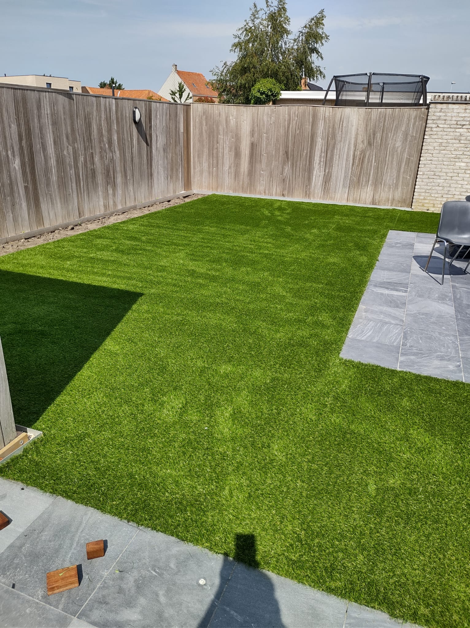 Onderhoudsvriendelijk kunstgras naast een terras in keramische tegels